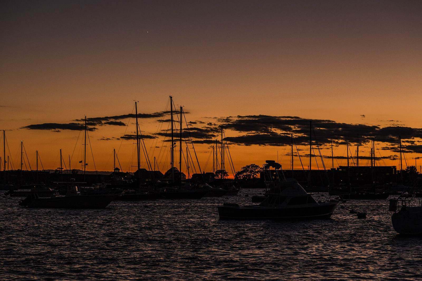 Evening twilight over Newport Harbor with sailboats at anchor